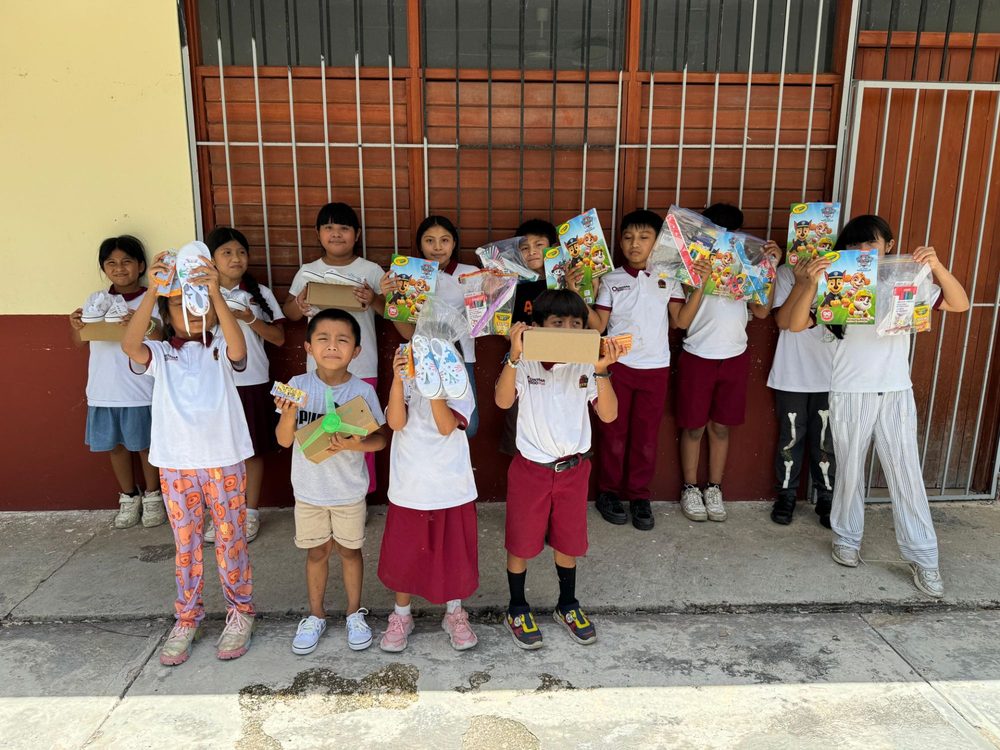 Niñas y niños con los útiles escolares y tenis decorados que recibieron
